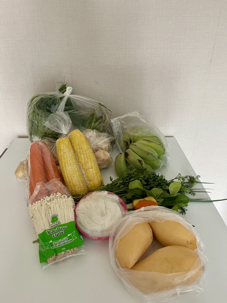 タイの食材、マンゴー とうもろこし 人参などがテーブルの上に並んでいる