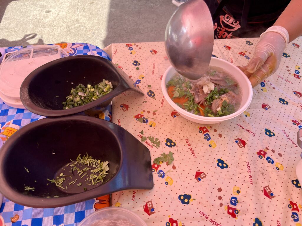 器に入った米麺へスープをかけている様子