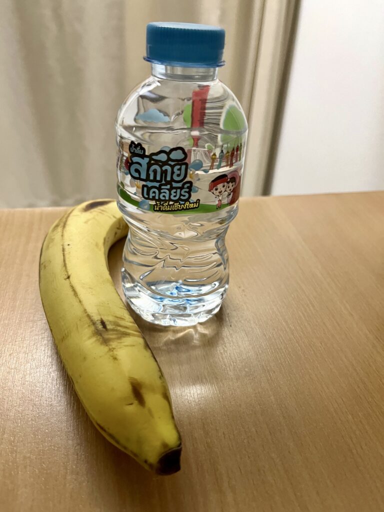 机の上にバナナ1本と小さなボトルウォーター