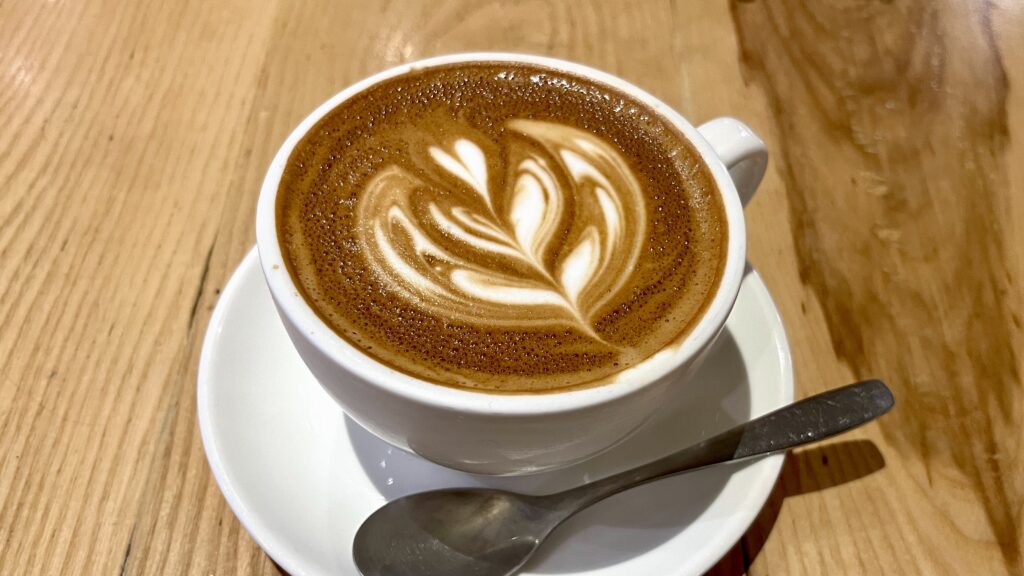テーブルにラテアートが書かれたカフェラテ