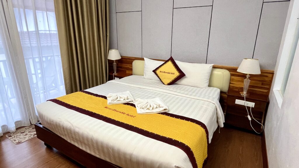 宿泊したホテルMerry Riverside Hotelの客室内、真ん中に大きなベッドがある