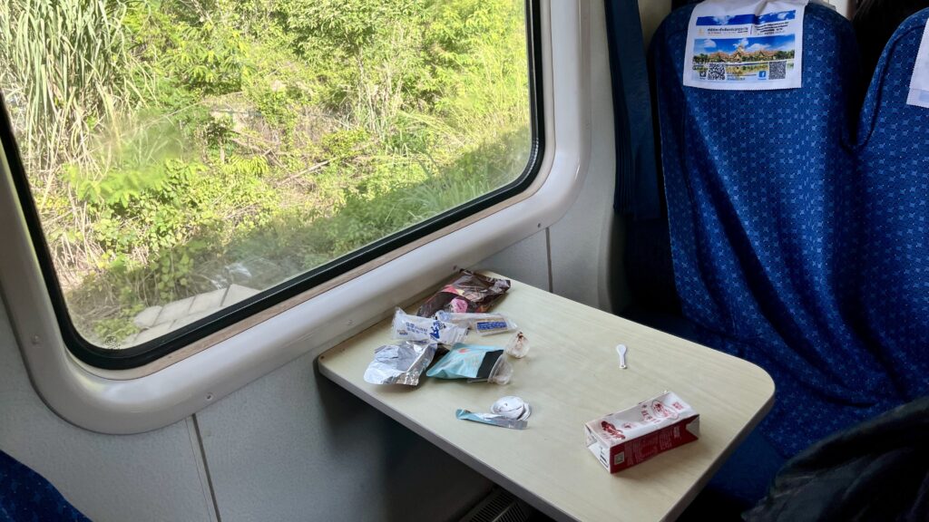 中国ラオス鉄道の列車内の様子、客席のテーブルにはゴミが散乱している