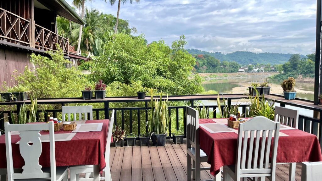 ホテルMerry Riverside Hotelの朝食会場、テラスにテーブルと椅子がありリバービュー