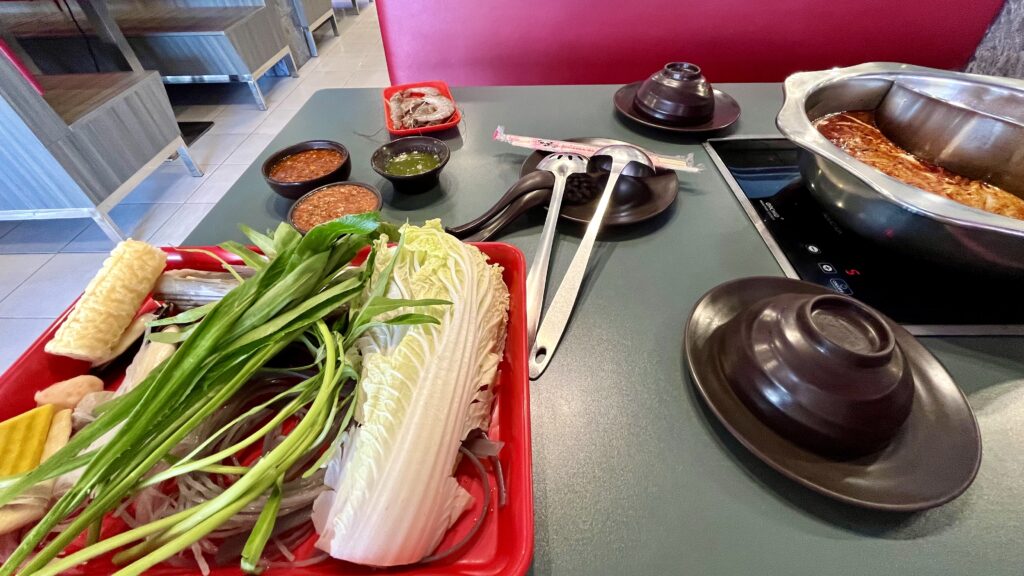 スキ ダーラーの店内、テーブルに鍋や野菜などが並ぶ