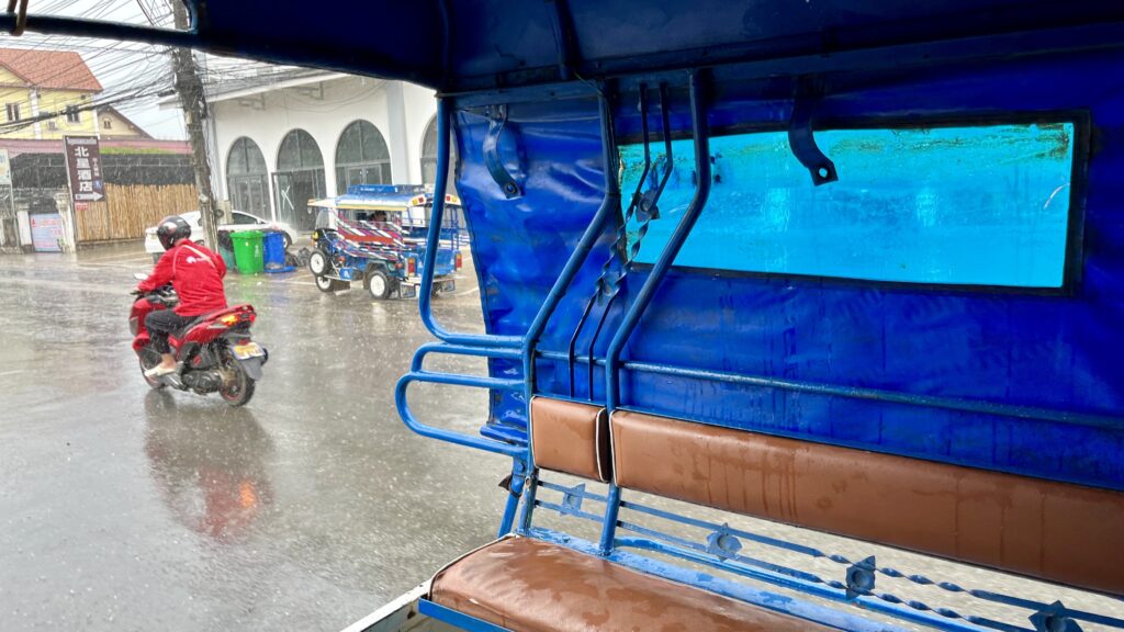 ルアンパバーンにて、雨の中を走るソンテウの様子