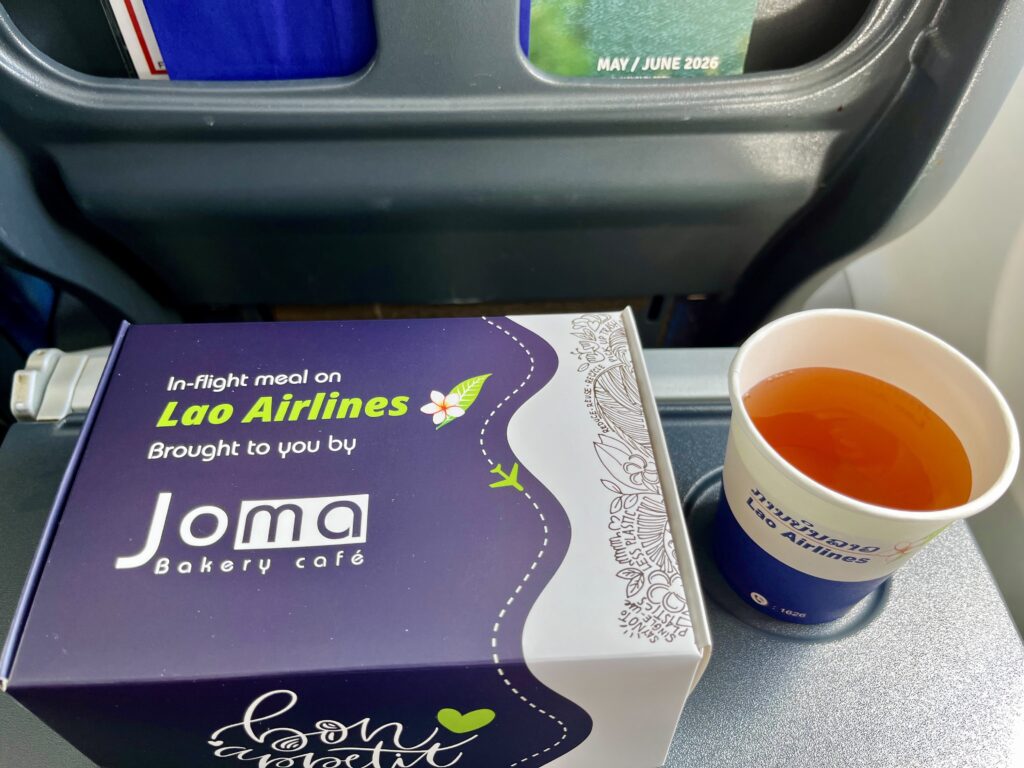 テーブルにJoma（ジョマ）ベーカリーカフェと書かれたボックスと、紙コップに入った紅茶が置いてある