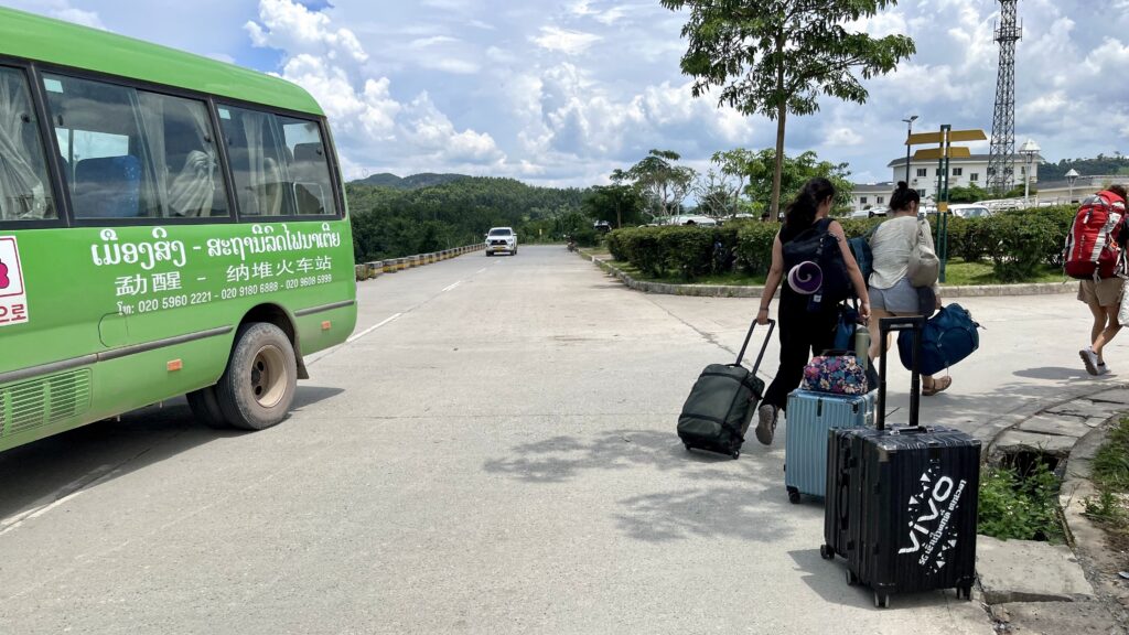 中国ラオス鉄道のナトゥイ駅の様子、スーツケースを持った旅行客が数名歩いている