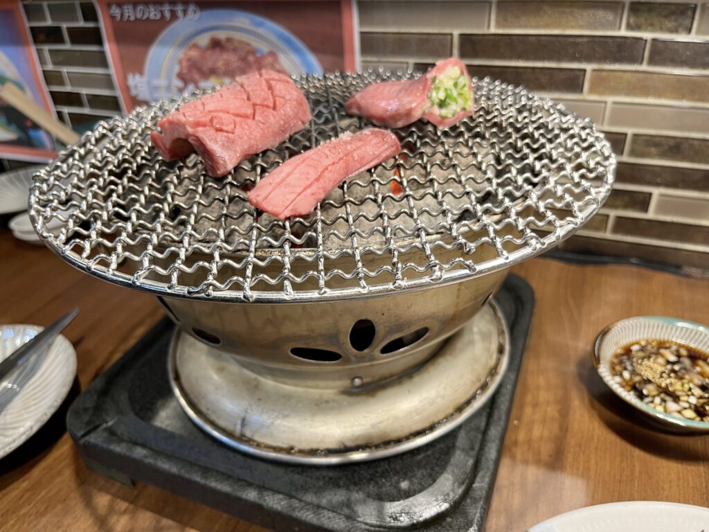 日本街(にほんまち/Nihonmachi)にあるおにくとごはん。の卓上コンロで、牛タンを焼く