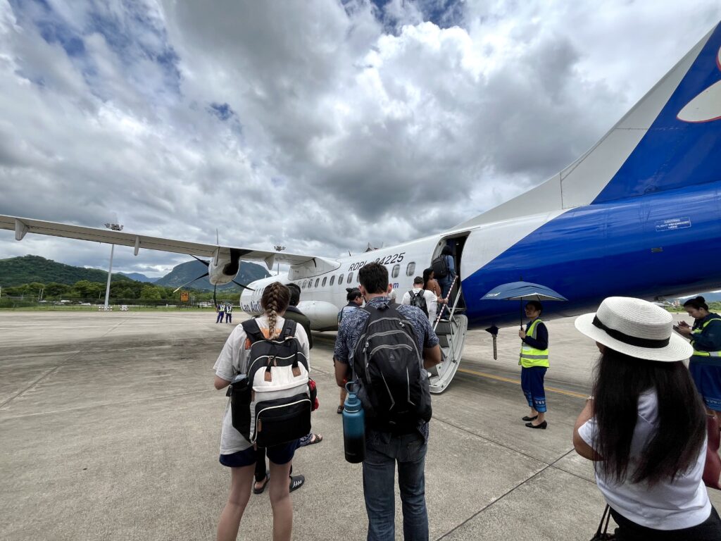 ラオス航空のプロペラ機へ、乗客が後方口から乗り込む様子