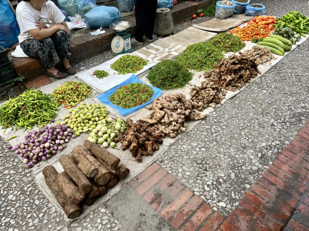 Luang Prabang morning marketに並ぶ野菜、左手前にTanakaが積まれている
