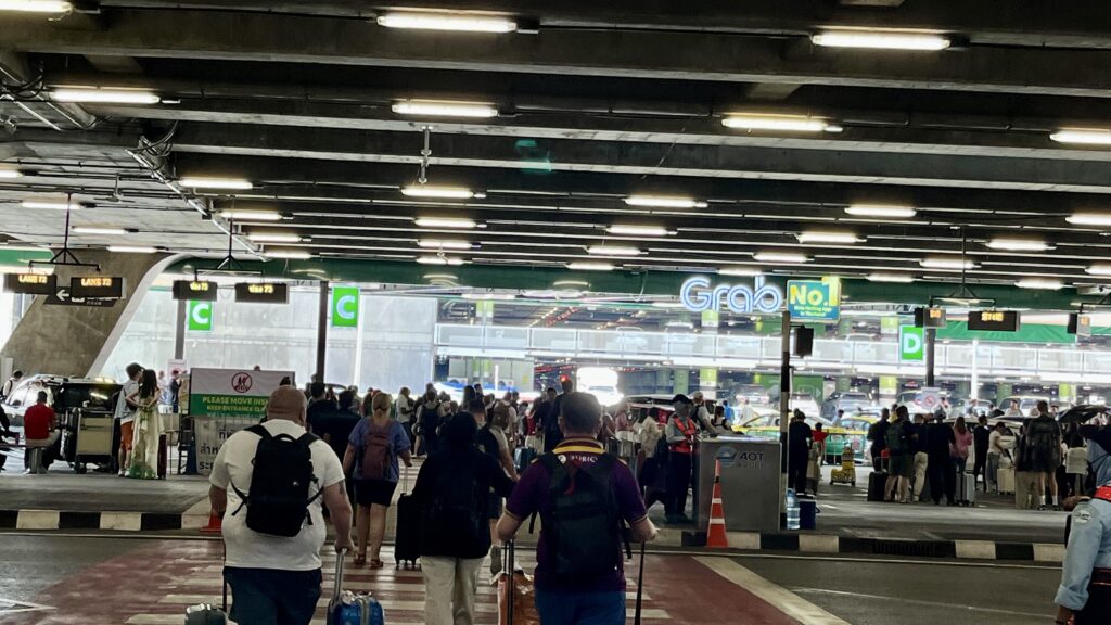 スワンナプーム国際空港のGrabピックアップポイントへ向かう、多くの観光客