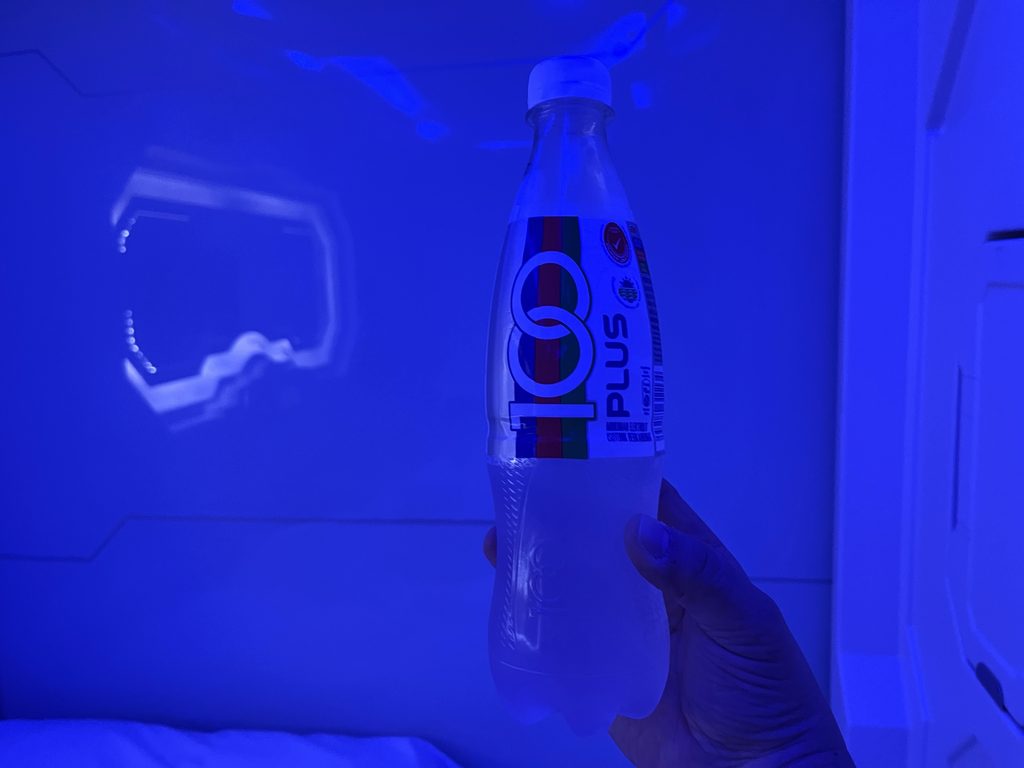 スペースホテルの室内で撮った100PLUS、照明で青白く光る