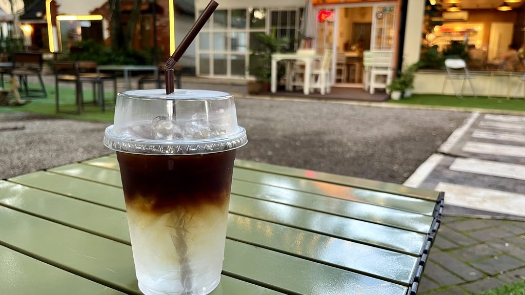 Landin前の庭先のテーブルに置かれたアイスココナッツコーヒー