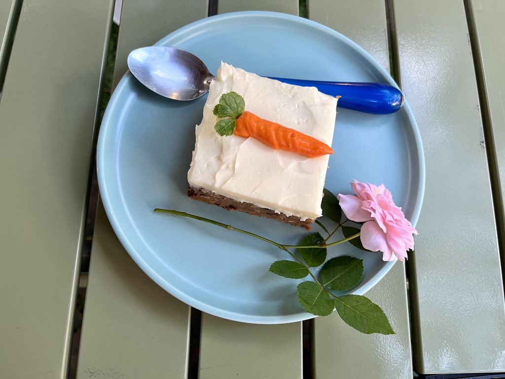 Landin前の庭先のテーブルに置かれたキャロットケーキ、薔薇が一輪添えられてある