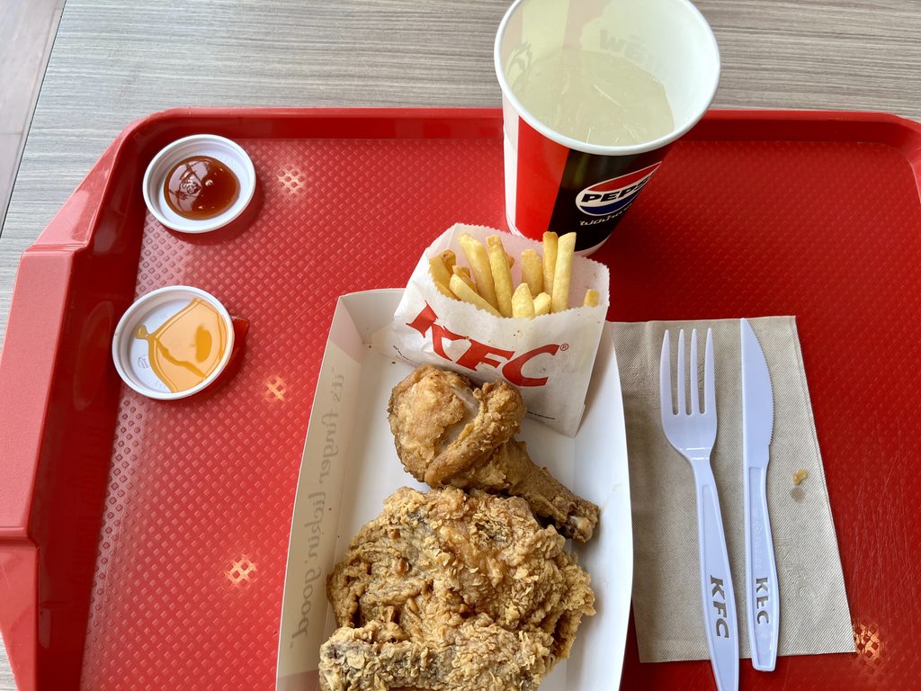 赤いトレー内にKFC(ケンタッキーフライドチキン)のフライドチキンが乗っている様子