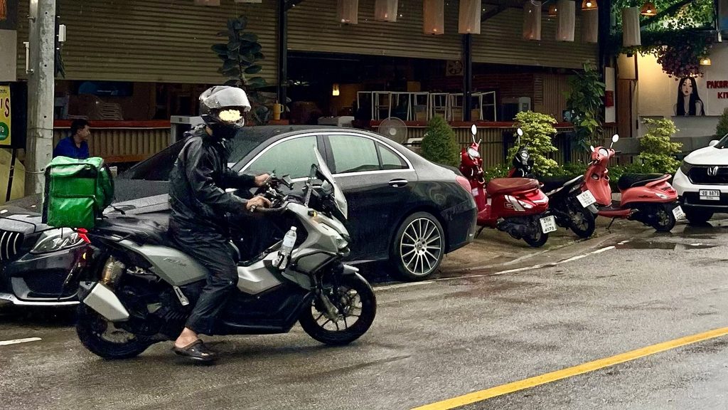 チェンマイ市内の道路、バイクに跨ったGrabドライバーの様子